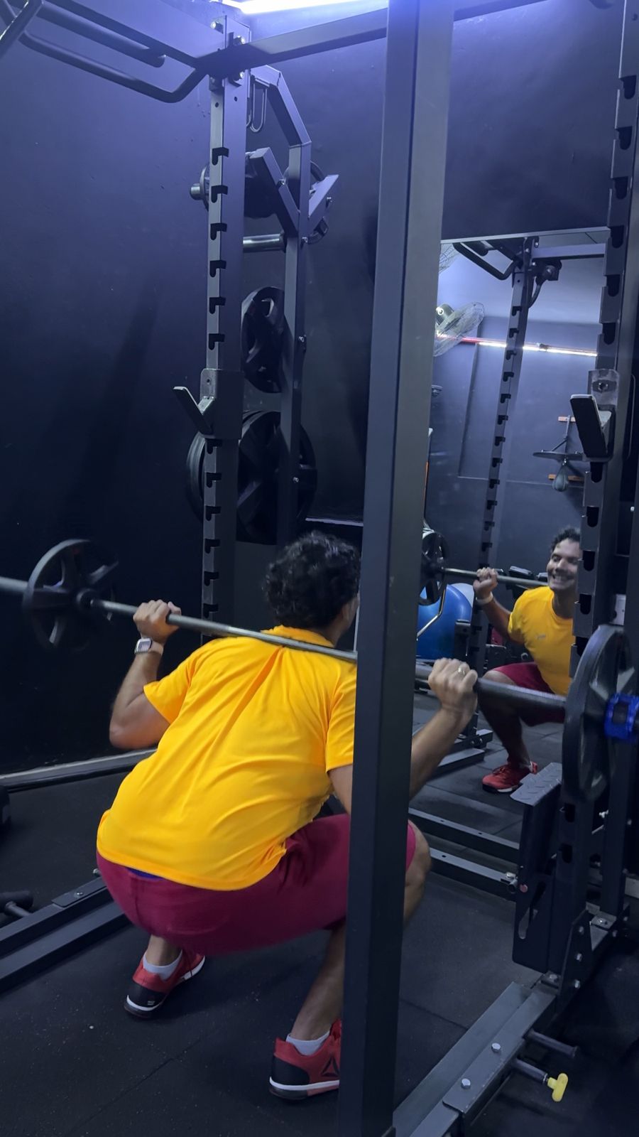 Client back squat to full depth in a home gym