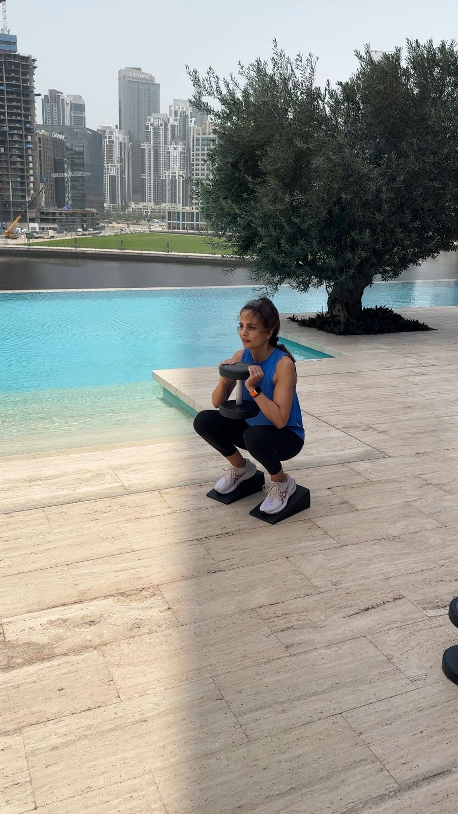 Outdoor personal training session: goblet squat by the pool in Dubai